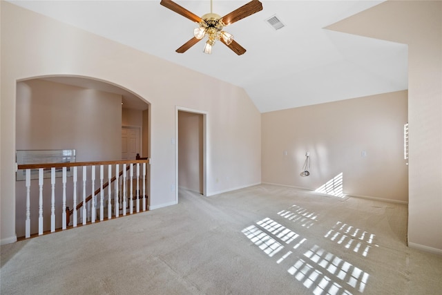 empty room featuring ceiling fan, vaulted ceiling, and light carpet