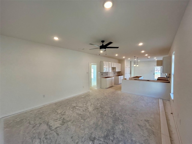 unfurnished living room featuring ceiling fan