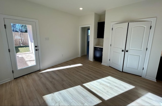 unfurnished bedroom featuring connected bathroom, light hardwood / wood-style floors, and a closet