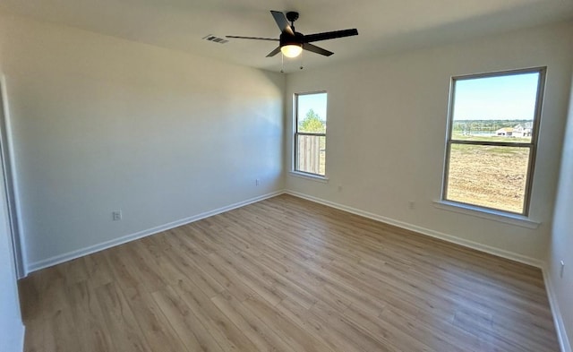 spare room with ceiling fan and light wood-type flooring