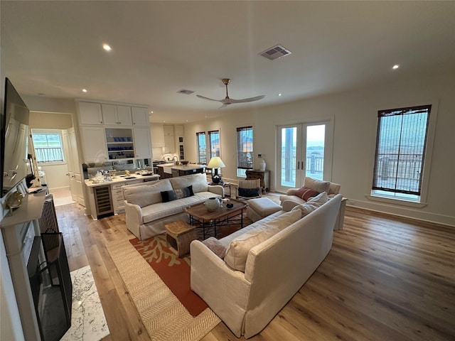 living room featuring french doors, light hardwood / wood-style floors, and ceiling fan