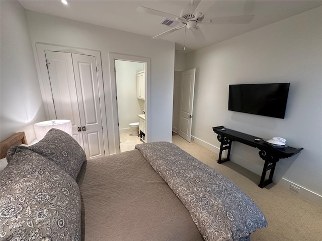 bedroom featuring ceiling fan, light carpet, connected bathroom, and a closet