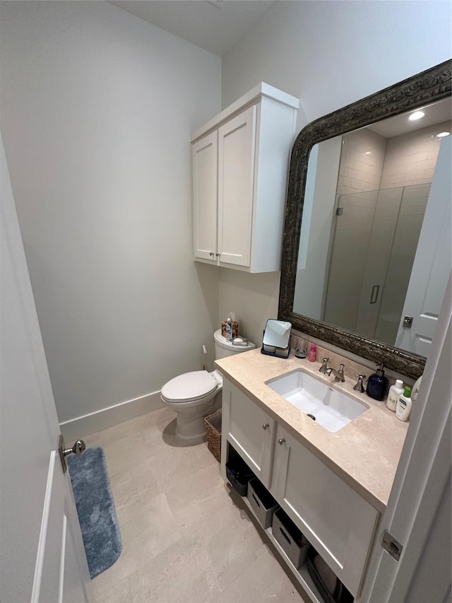 bathroom featuring vanity, toilet, and a shower with shower door