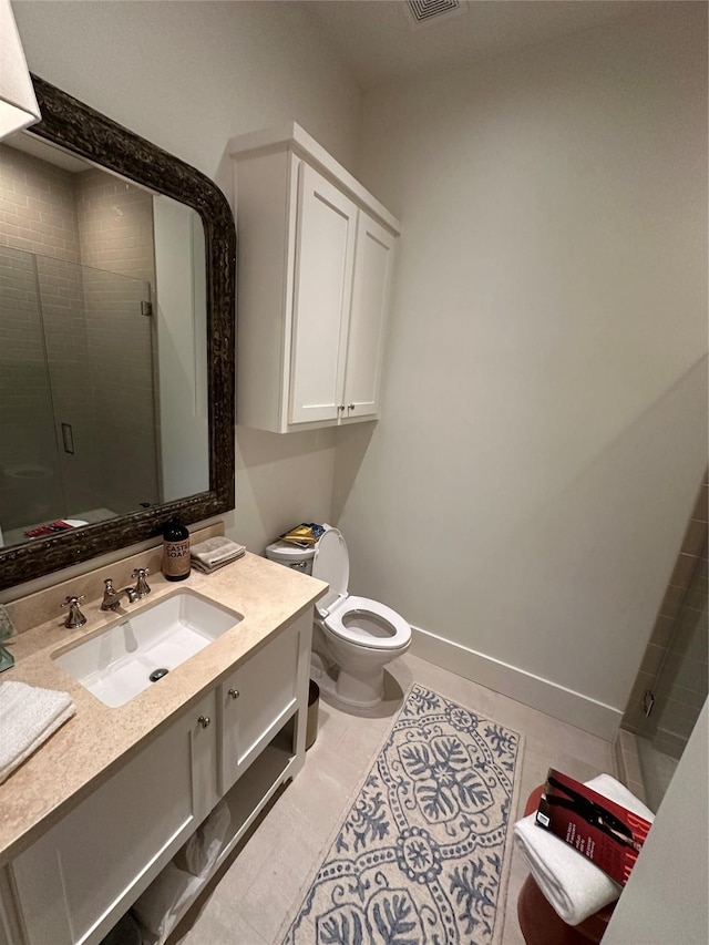 bathroom with tile patterned floors, vanity, toilet, and a shower with door