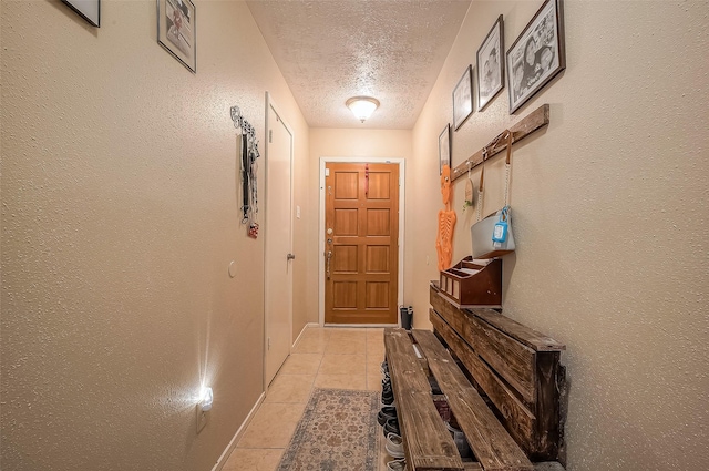 entryway with light tile patterned floors and a textured ceiling