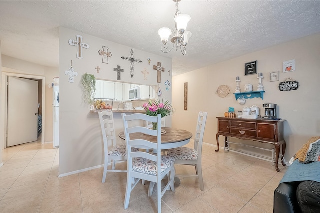 tiled dining area with a textured ceiling and a notable chandelier