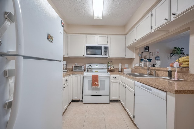 kitchen with white cabinetry, light tile patterned flooring, white appliances, and sink