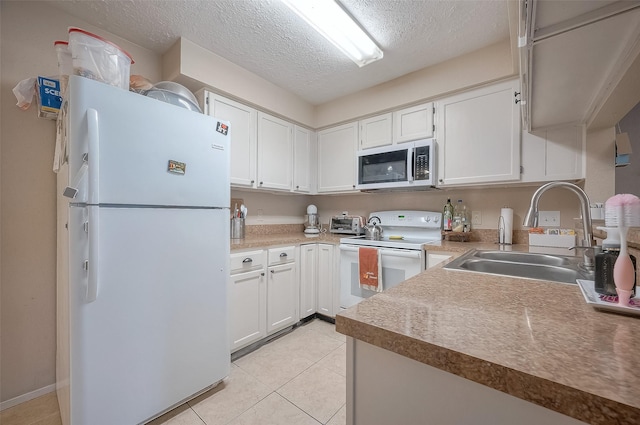 kitchen with white appliances, white cabinets, sink, a textured ceiling, and light tile patterned flooring