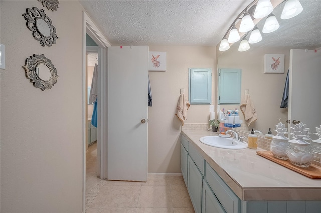 bathroom featuring tile patterned floors, vanity, and a textured ceiling