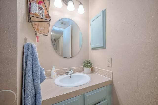 bathroom featuring vanity and backsplash