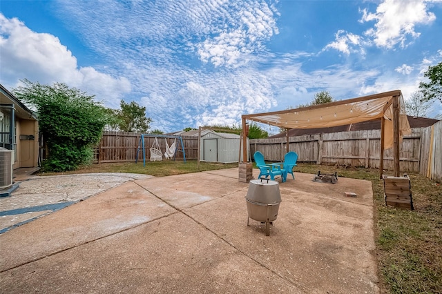 view of patio / terrace with a shed and a fire pit