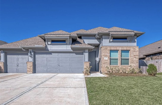 prairie-style home featuring a garage and a front lawn