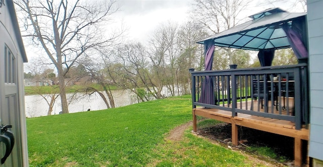 view of yard featuring a deck with water view and a gazebo