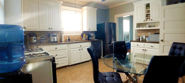 kitchen with white cabinets, crown molding, sink, black dishwasher, and light tile patterned flooring