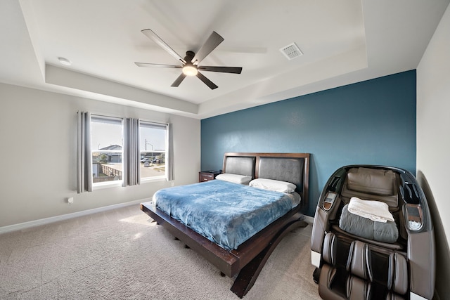 bedroom with carpet, ceiling fan, and a raised ceiling