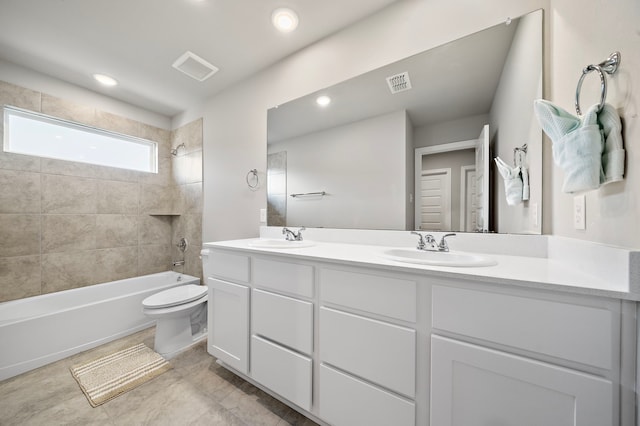 full bathroom with vanity, tiled shower / bath combo, and toilet