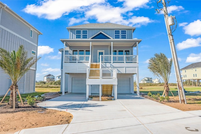 coastal home with a balcony, a porch, and a garage