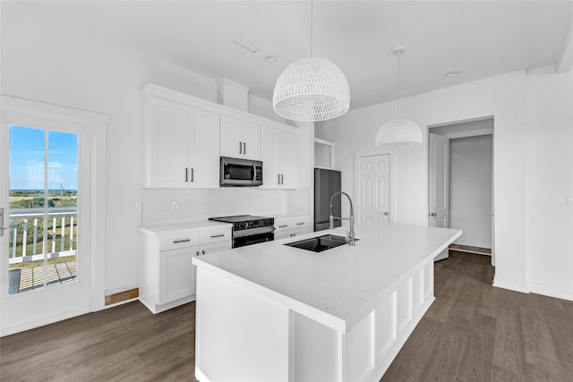 kitchen with white cabinets, electric range, an island with sink, and hanging light fixtures