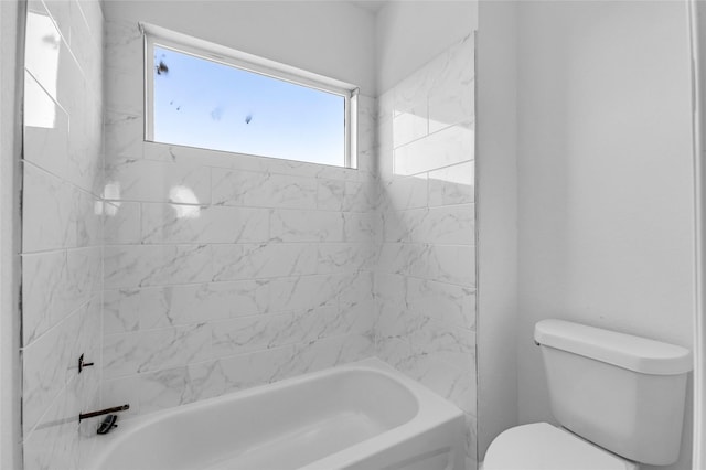 bathroom featuring toilet and tiled shower / bath