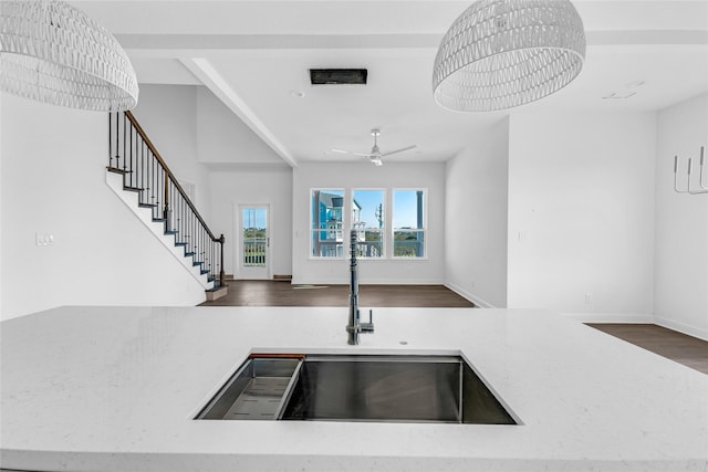 kitchen featuring sink, dark wood-type flooring, and ceiling fan with notable chandelier