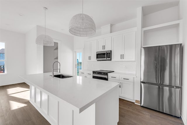 kitchen featuring pendant lighting, white cabinetry, sink, and appliances with stainless steel finishes