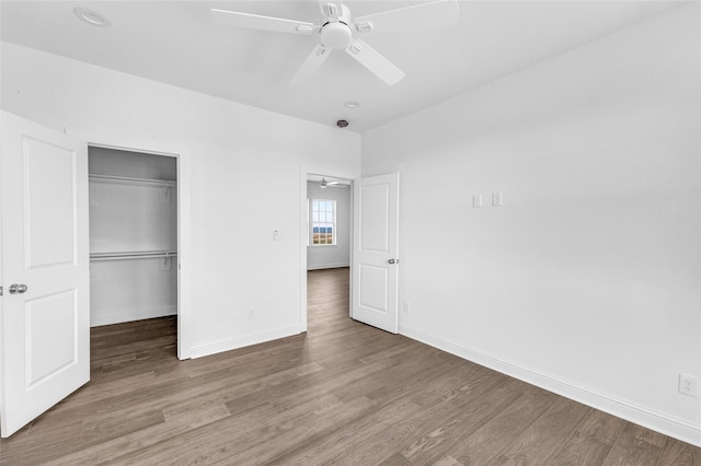 unfurnished bedroom featuring ceiling fan, a closet, and hardwood / wood-style flooring