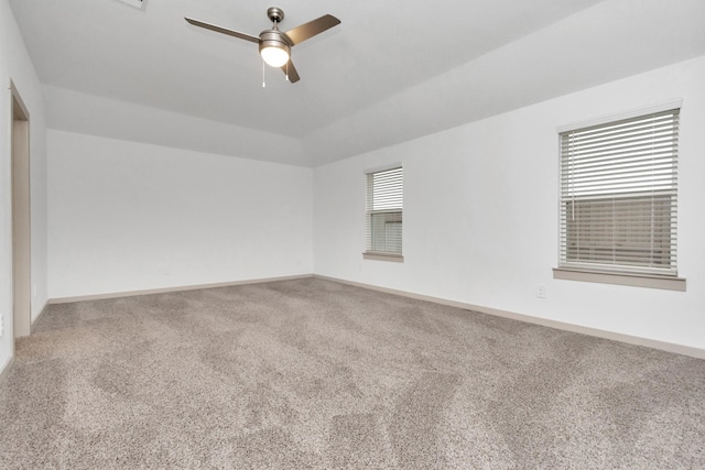 carpeted spare room with ceiling fan and vaulted ceiling