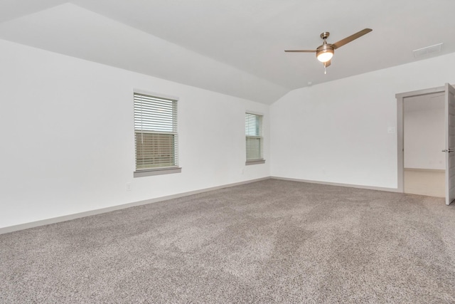 empty room with ceiling fan, lofted ceiling, and carpet floors