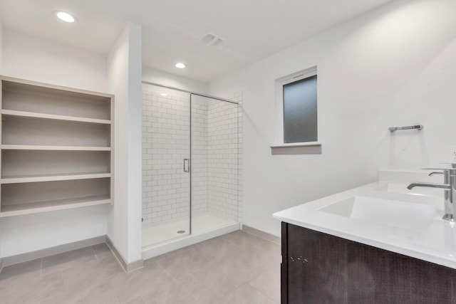 bathroom with an enclosed shower, vanity, and tile patterned floors