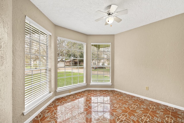 tiled spare room with ceiling fan, a healthy amount of sunlight, and a textured ceiling