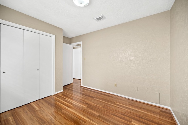 unfurnished bedroom featuring hardwood / wood-style flooring and a closet