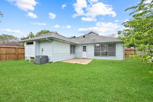 rear view of property featuring a patio area, a yard, and central AC