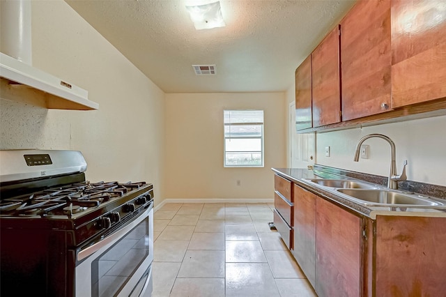 kitchen featuring light tile patterned floors, a textured ceiling, sink, extractor fan, and gas range