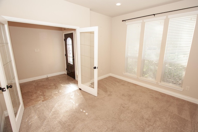 unfurnished bedroom with light carpet and french doors