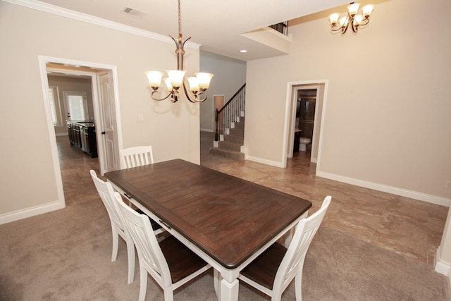 dining area featuring carpet floors, ornamental molding, and an inviting chandelier