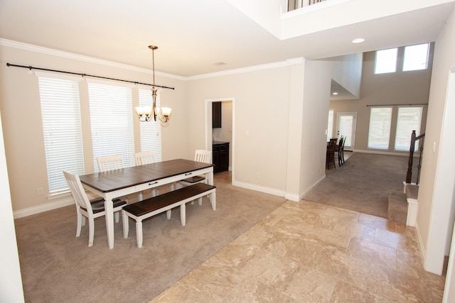 dining room with light carpet, an inviting chandelier, a high ceiling, and ornamental molding