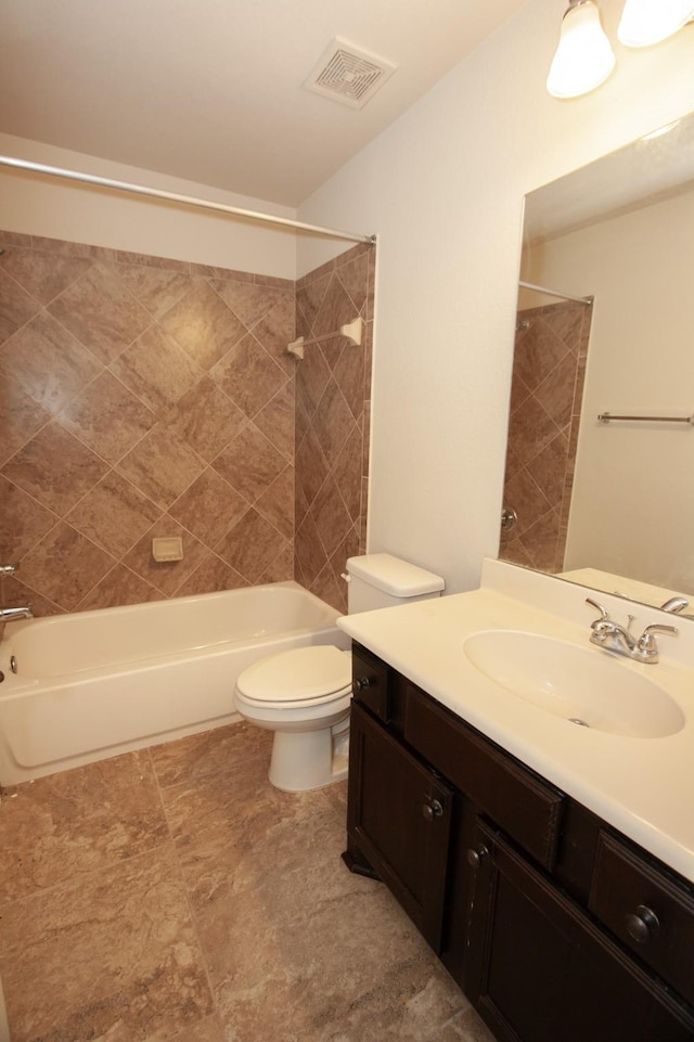 full bathroom with vanity, tiled shower / bath combo, and toilet