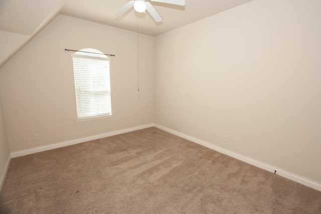 carpeted empty room with vaulted ceiling and ceiling fan