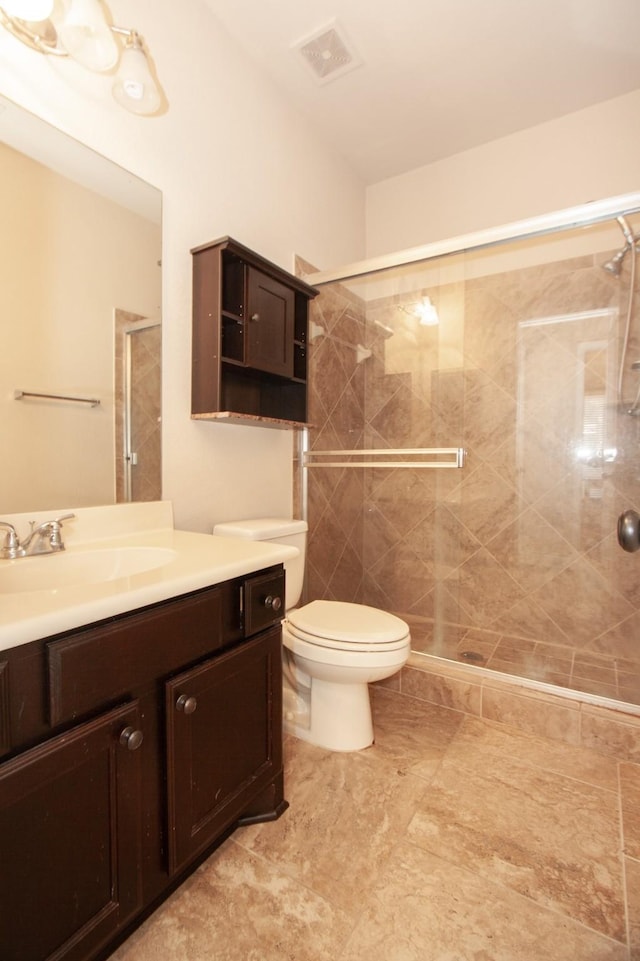 bathroom featuring vanity, toilet, and a shower with door