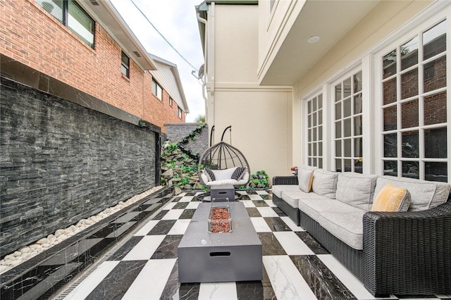 view of patio with an outdoor living space with a fire pit