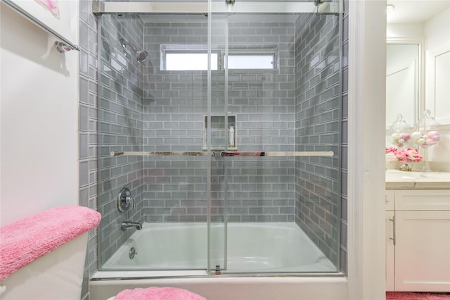 bathroom featuring vanity and bath / shower combo with glass door