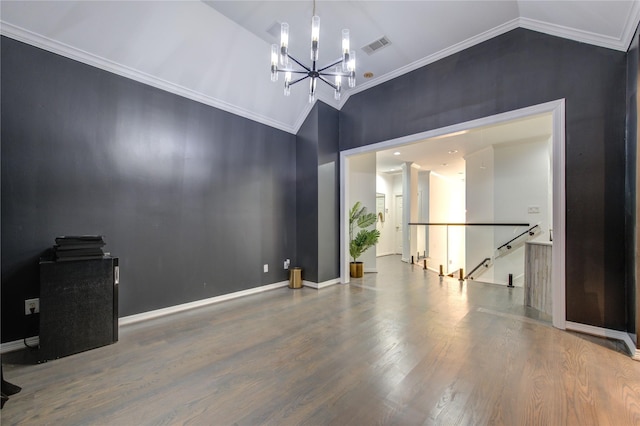 spare room with a chandelier, lofted ceiling, and ornamental molding