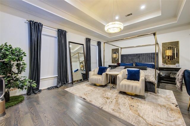 bedroom featuring a notable chandelier, a raised ceiling, and dark wood-type flooring