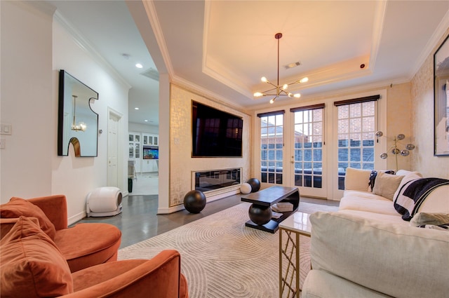 living room with a raised ceiling, ornamental molding, and a notable chandelier