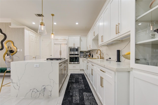 kitchen featuring white cabinets, light stone countertops, and hanging light fixtures