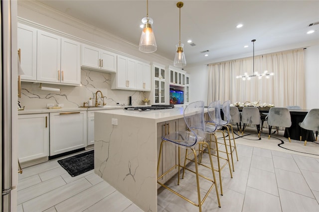 kitchen featuring decorative light fixtures, a kitchen island, white cabinetry, and backsplash