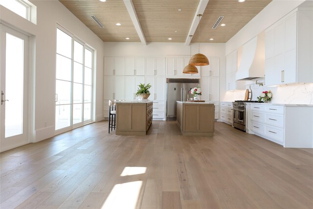 kitchen with white cabinetry, custom range hood, a kitchen island, high quality appliances, and pendant lighting