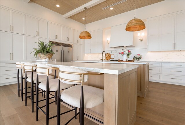 kitchen with white cabinetry, built in refrigerator, wooden ceiling, and beam ceiling