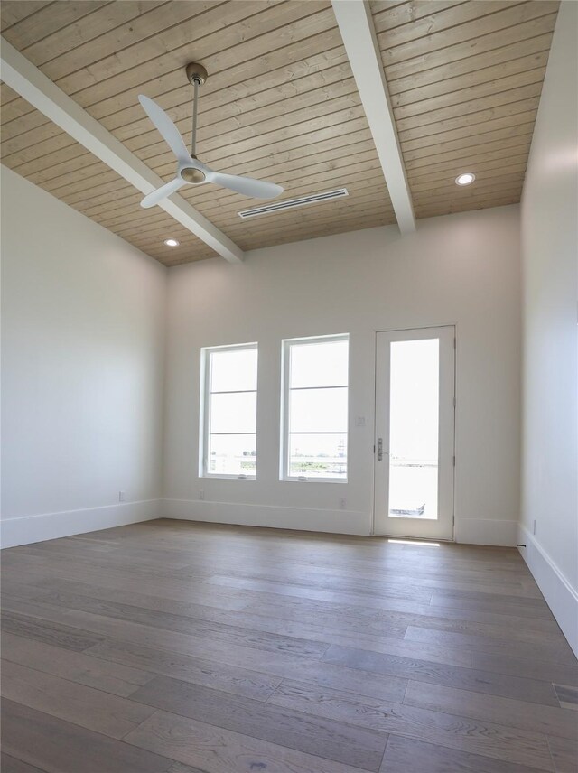 empty room with beam ceiling, wood ceiling, ceiling fan, and hardwood / wood-style flooring