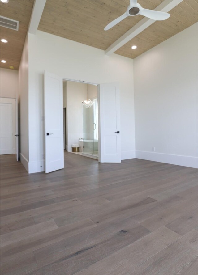 unfurnished room with wooden ceiling, ceiling fan, wood-type flooring, a high ceiling, and beam ceiling